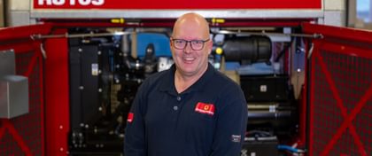 Porträtfoto von Ronny vor einem geöffneten Stromaggregat